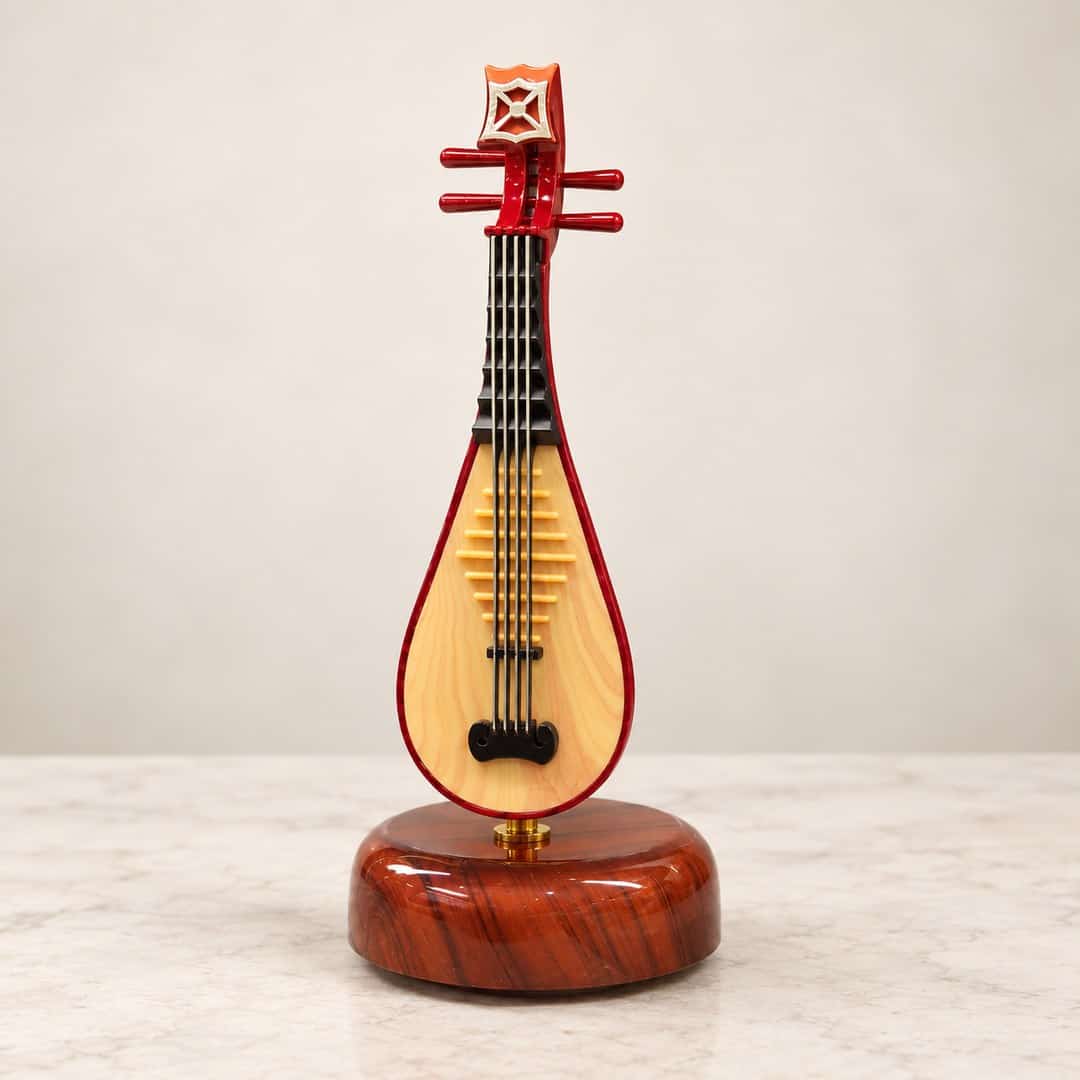 miniature red pipa table display with strings on a warm wood-look round base