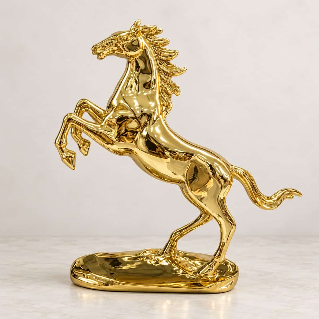 gold-tone rearing horse sculpture with flowing mane on a low decorative base