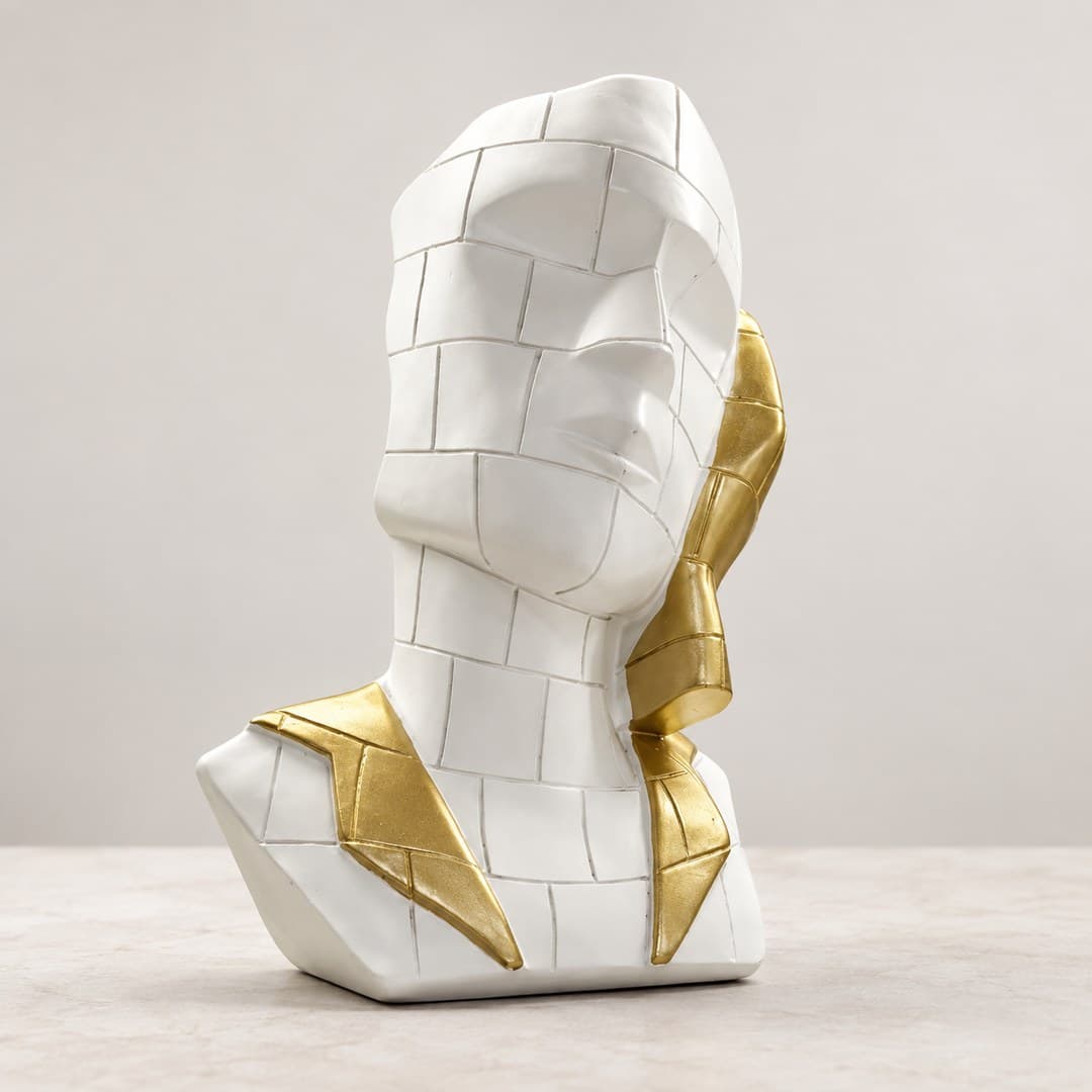 faceted white face sculpture with mosaic-style panels and a gold-tone side accent